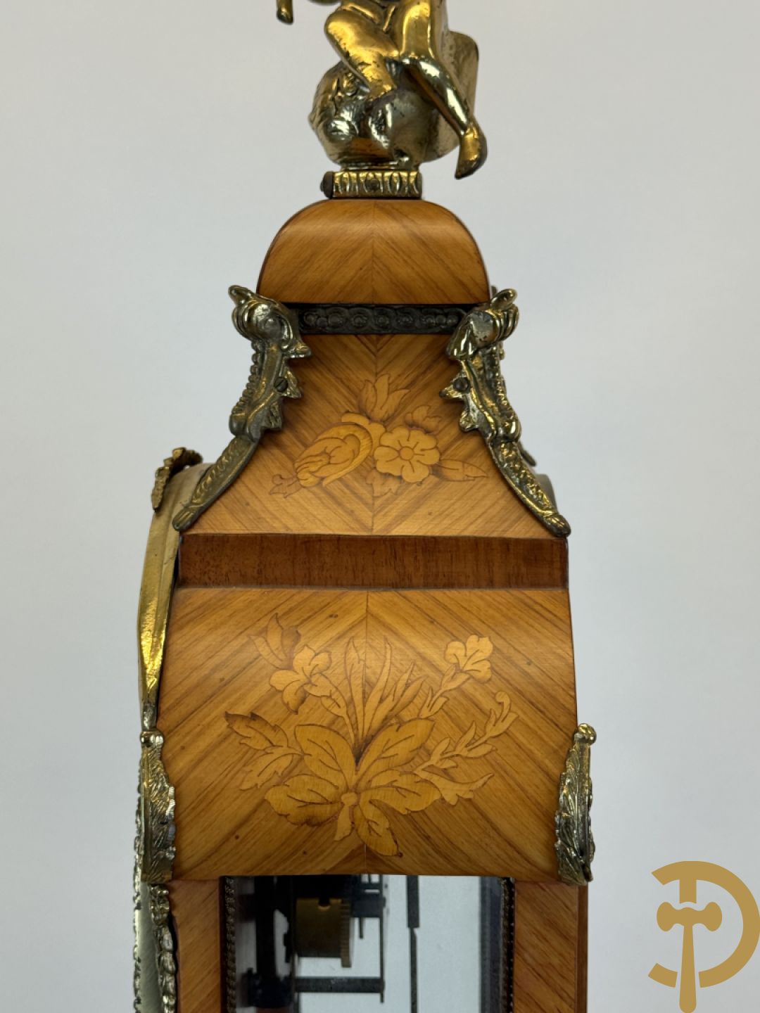 Notelaren pendule met bloemenmarquetterie en bronsbeslag, bovenaan bekroond met bronzen figuur - met bijhorende sokkel in notelaar met bronsbeslag