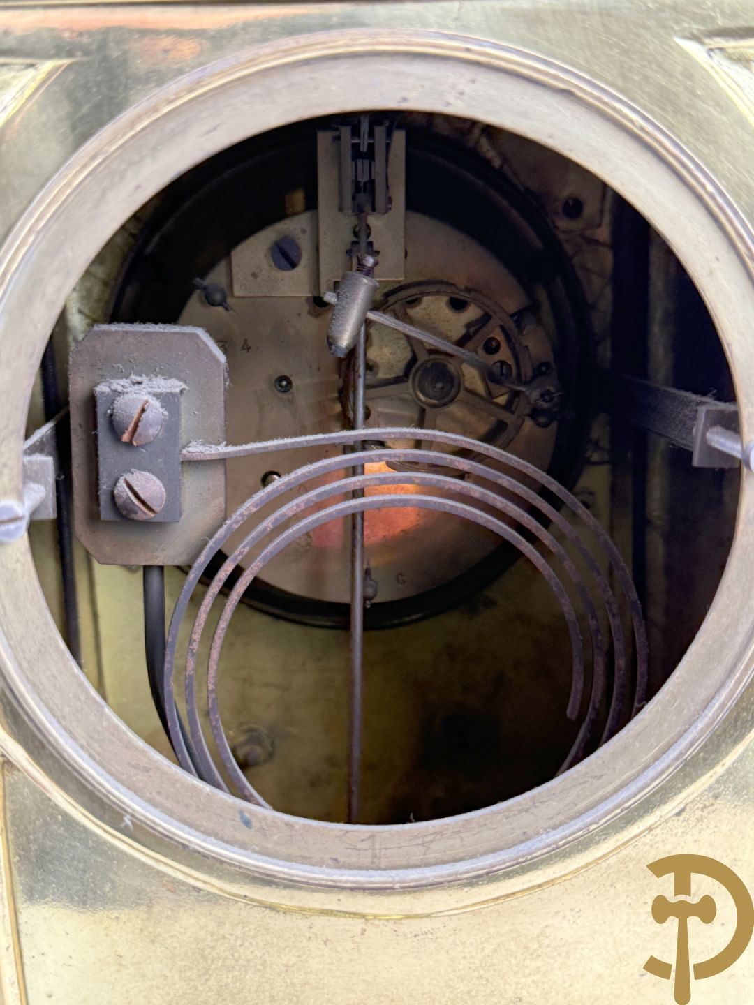 Driedelige bronzen vergulde garntiuur bestaande uit klok met medusahoofden en sfinxen, geflankeerd door paar zevenarmige kandelaars met accanthusranken en sfinxen