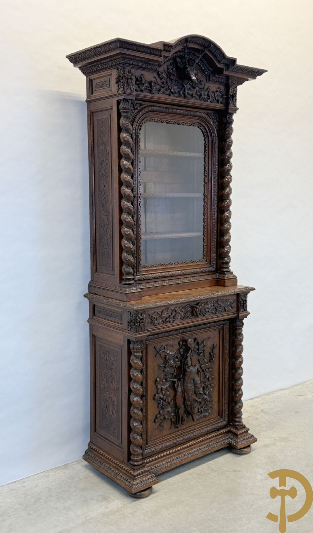 Massief eiken jacht deux-corps, bovenaan met vitrine, zijdelings met getorste zuilen, onderaan met sculptuur van everzwijn en eikebladranken