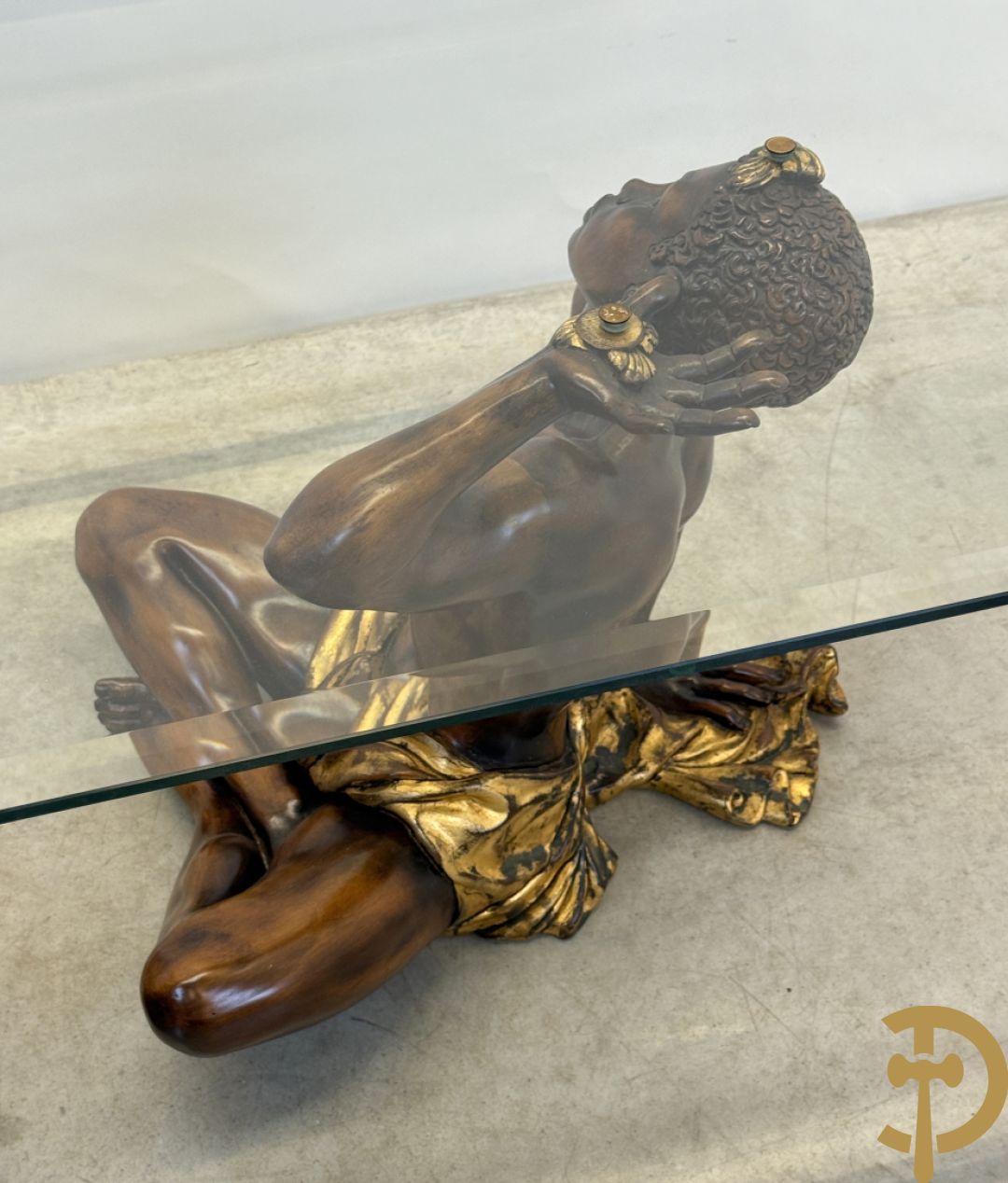 Salontafel met een paar moren met vergulde lendendoek dragende een achthoekig geslepen glazen blad