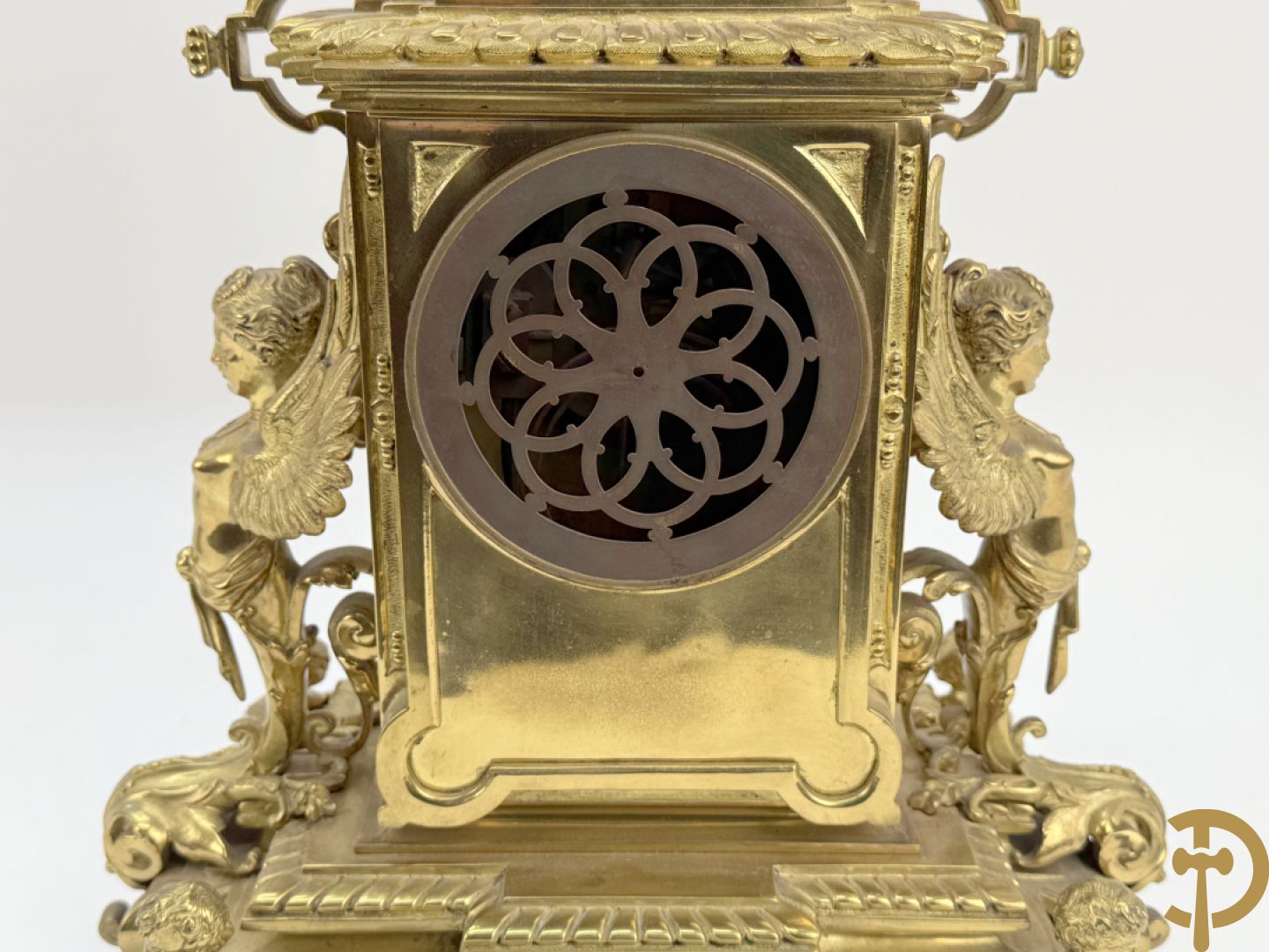 Driedelige bronzen vergulde garntiuur bestaande uit klok met medusahoofden en sfinxen, geflankeerd door paar zevenarmige kandelaars met accanthusranken en sfinxen