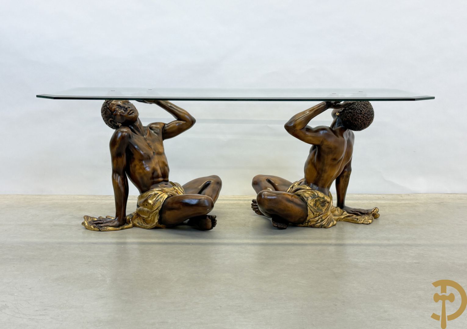 Salontafel met een paar moren met vergulde lendendoek dragende een achthoekig geslepen glazen blad