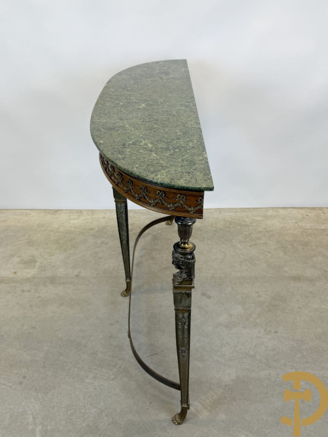 Console op bronzen poten met dameshoofden bezet, bovenaan met groen marmeren blad