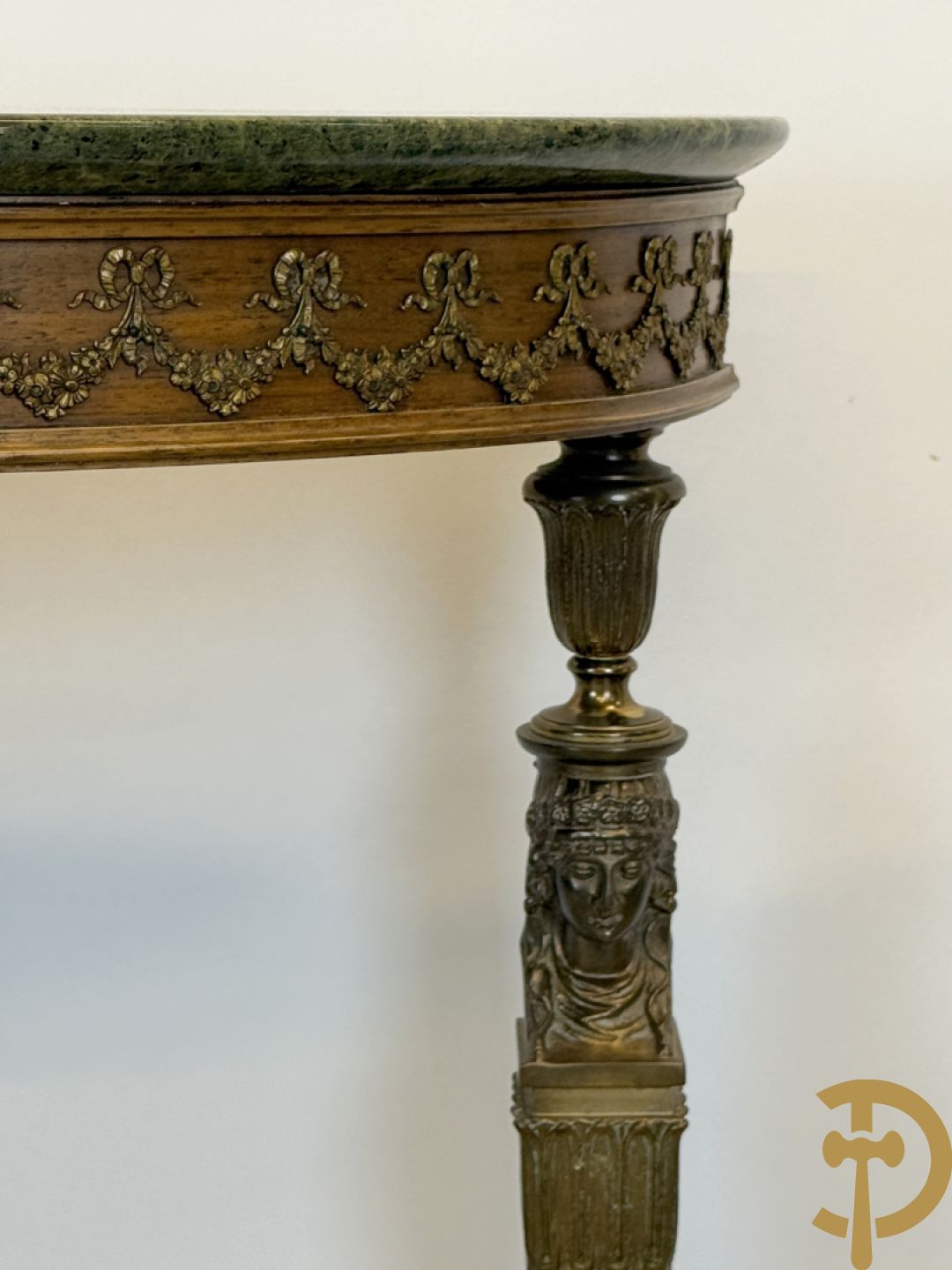 Console op bronzen poten met dameshoofden bezet, bovenaan met groen marmeren blad