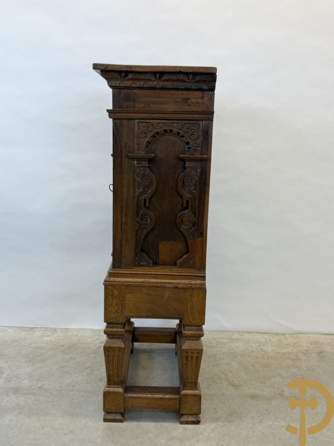 Massief eiken ééndeurskast op onderstel met lade bovenaan, lade onderaan, sculptuur in zijkant en deur