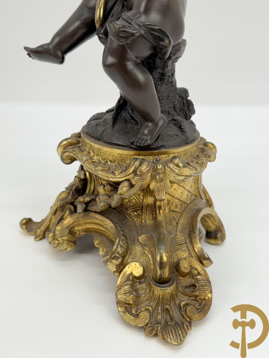 Bronzen cupido dragende een zevenarmige kandelaar