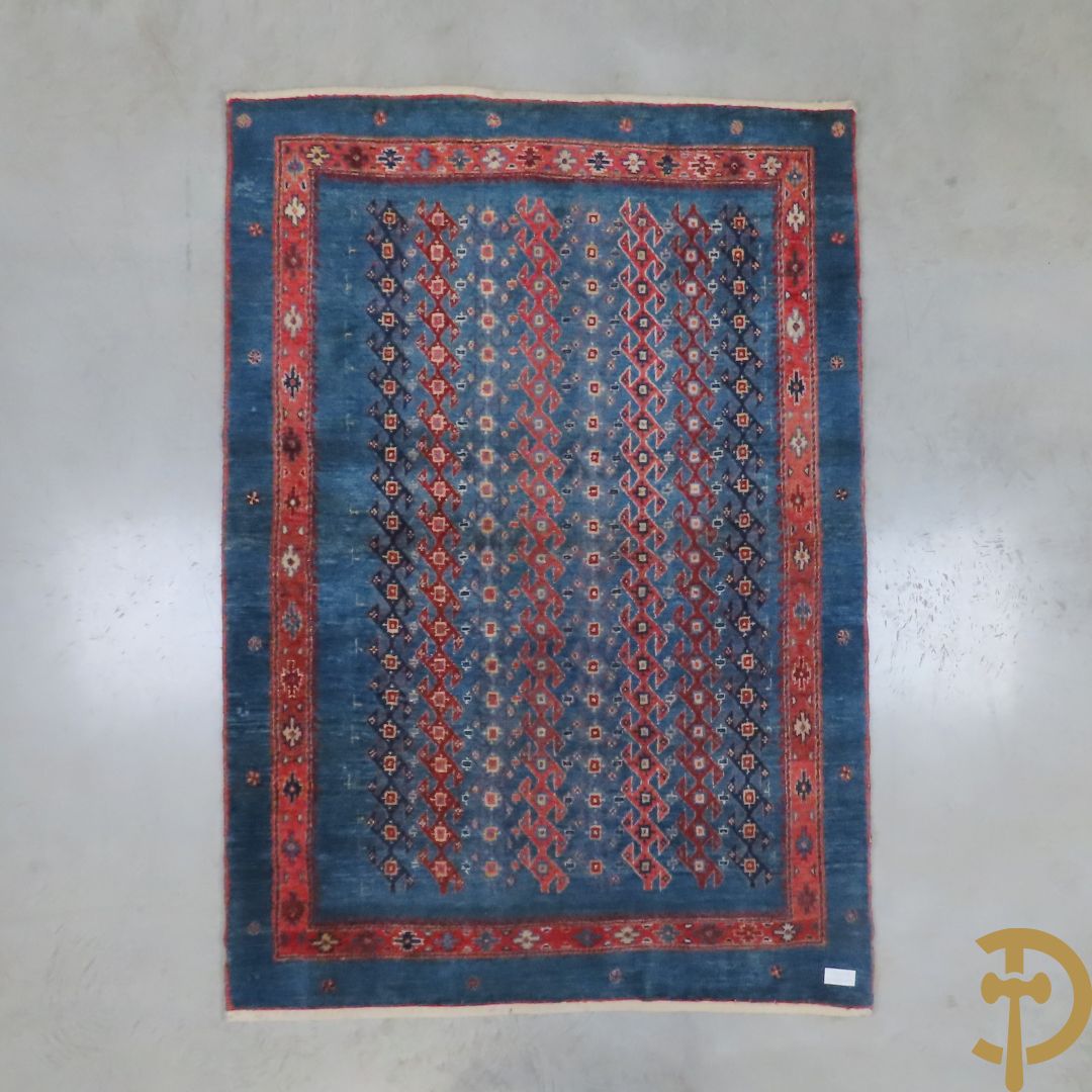 Oosters handgeknoopt tapijt met geometrische patronen op blauwe fond