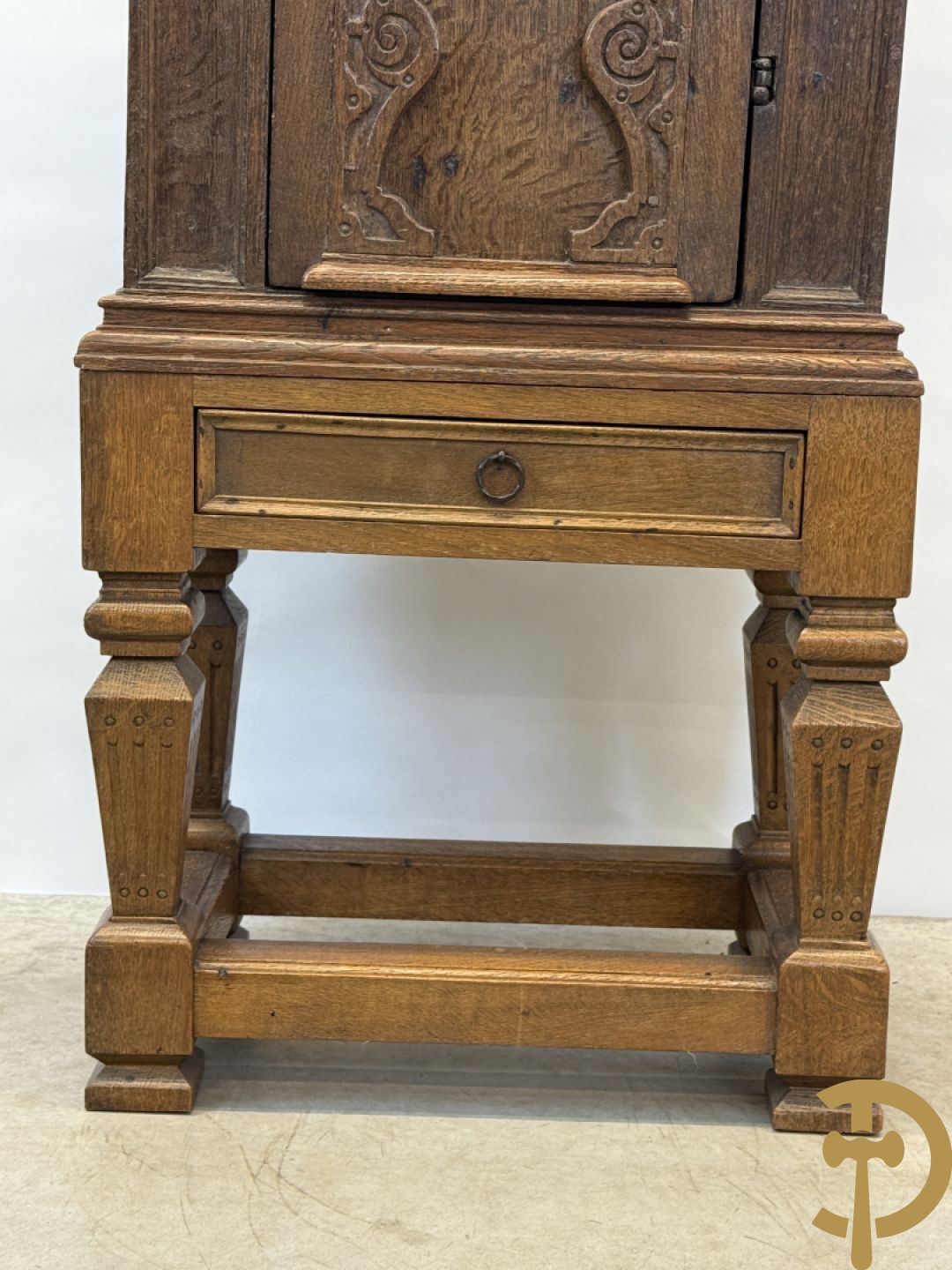 Massief eiken ééndeurskast op onderstel met lade bovenaan, lade onderaan, sculptuur in zijkant en deur