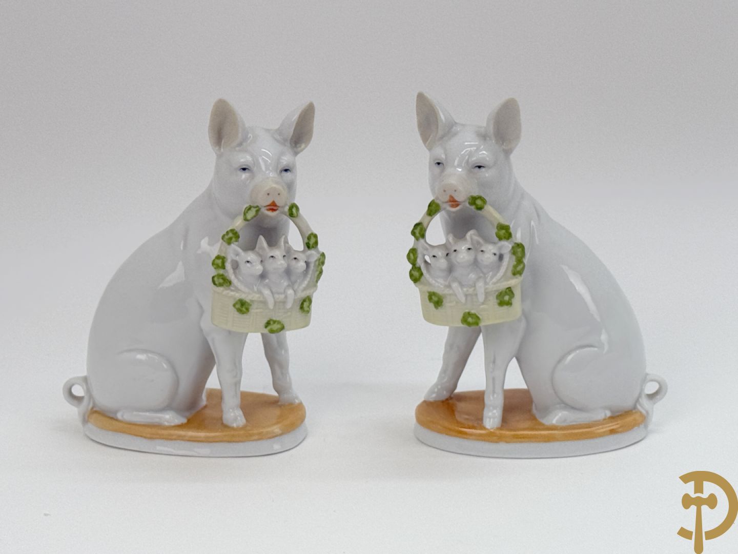 Koppel porseleinen beeldjes met varkens houdende een mandje met biggetjes