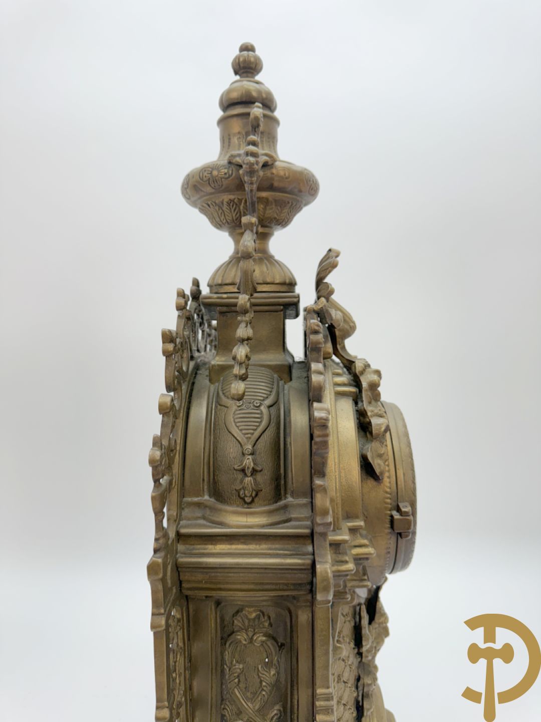 Driedelige koperen garnituur, klok geflankeerd door paar vijfarmige kandelaars