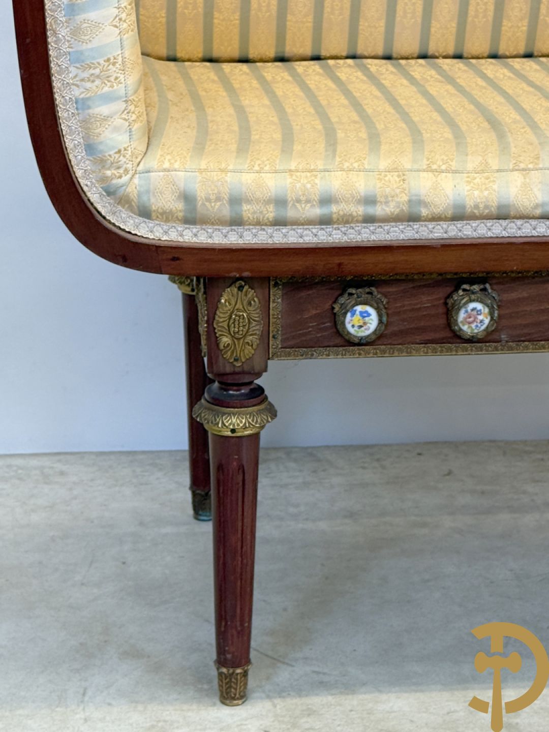 Banquette met ingebouwd bijzettafeltje bezet met porseleinen plakkettes op gecanneleerde poten