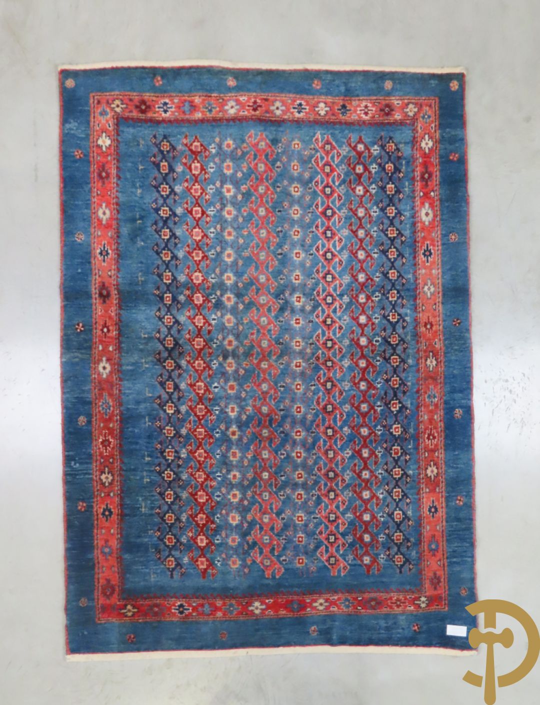 Oosters handgeknoopt tapijt met geometrische patronen op blauwe fond