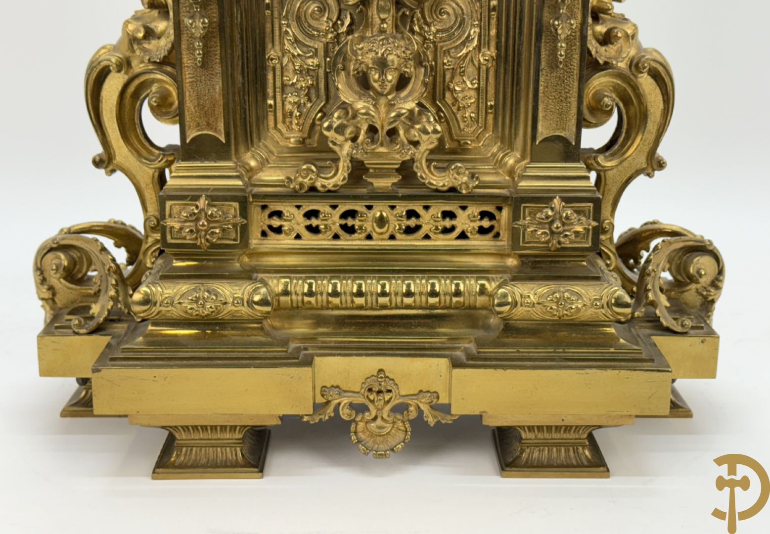 Vuurvergulde bronzen pendule, zijdelings bezet met gevleugelde dames, bovenaan met amfoor