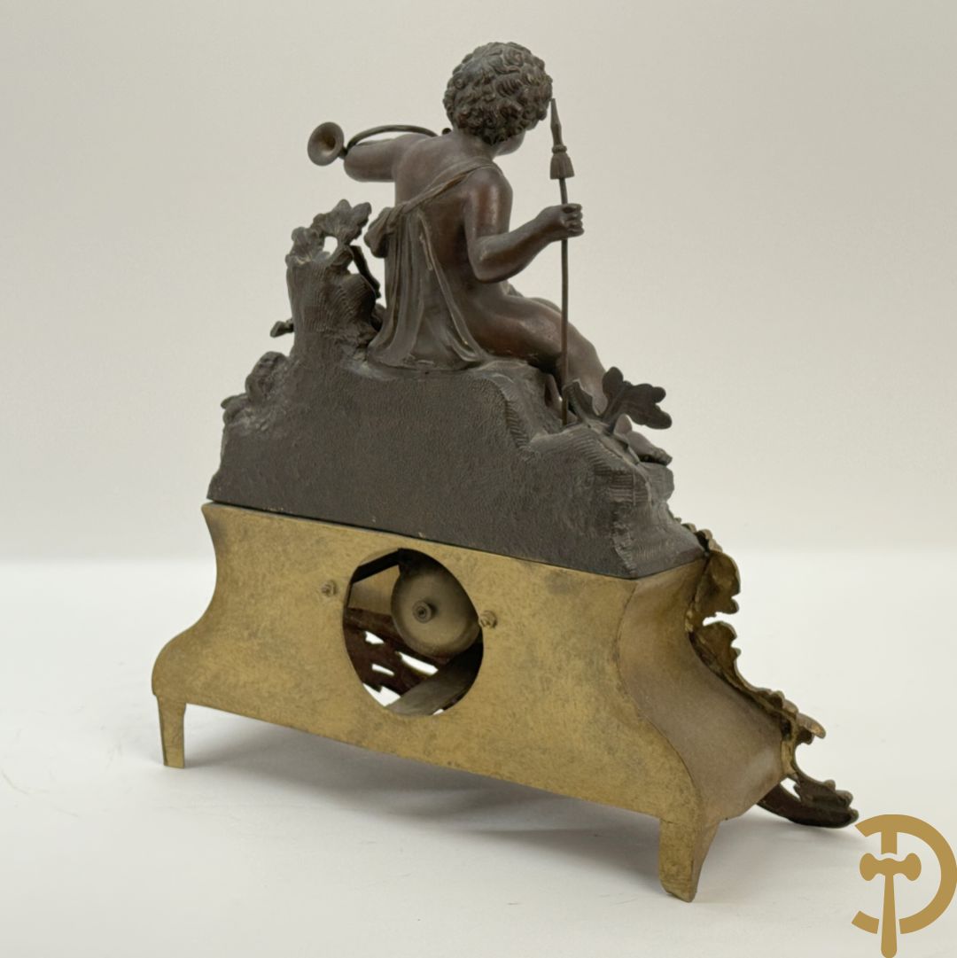 Zamak pendule met accanthusranken en bekroond met cupido met jachthoorn