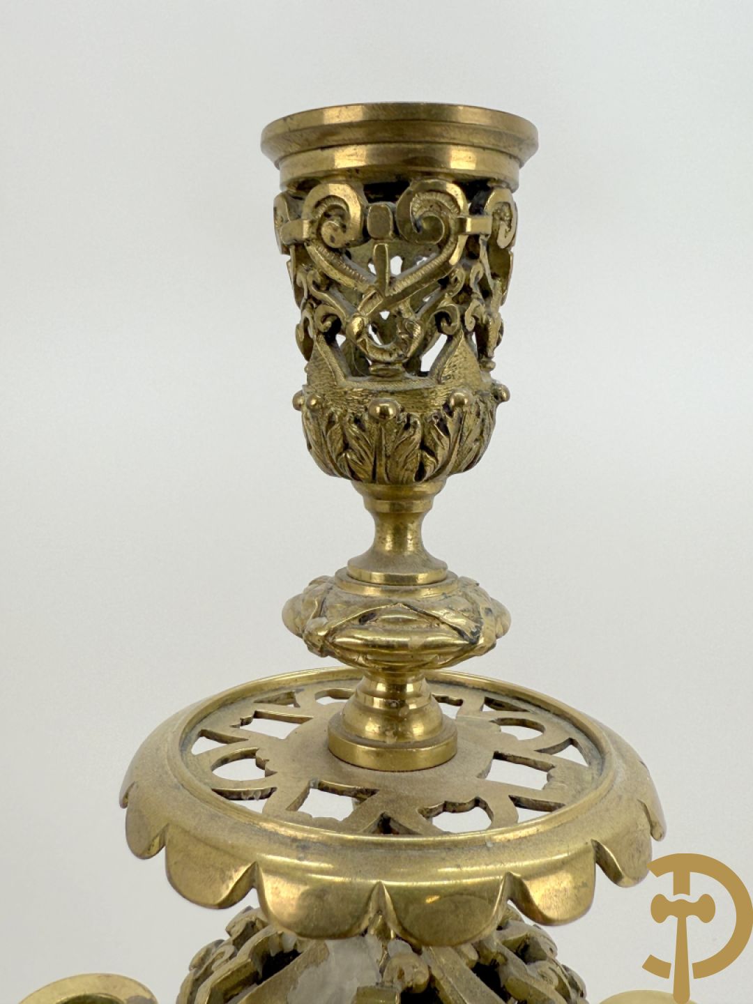 Driedelige bronzen vergulde garntiuur bestaande uit klok met medusahoofden en sfinxen, geflankeerd door paar zevenarmige kandelaars met accanthusranken en sfinxen