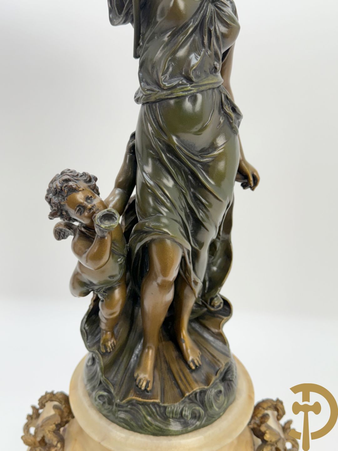 Driedelige zamak garnituur bestaande uit pendule met cupido en dame geflankeerd door paar vijfarmige kandelaars, Bruchon getekend