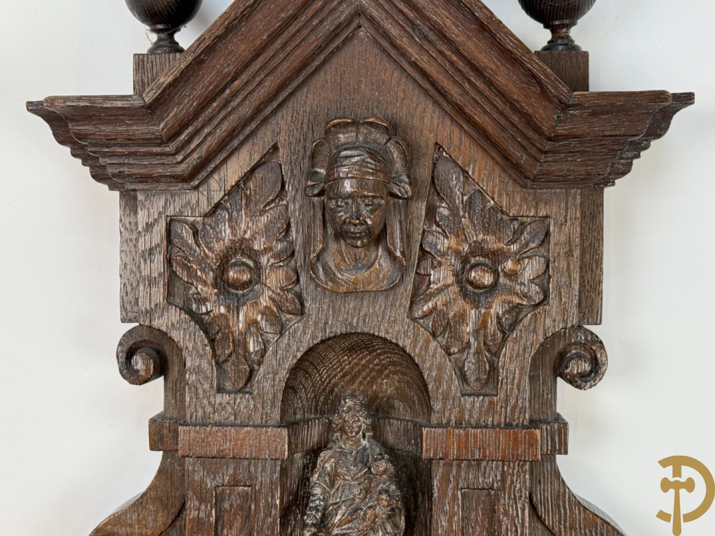 Kleine Madonna met kind in houtgesculpteerde nis, onderaan met cupidohoofd en bovenaan met fronton