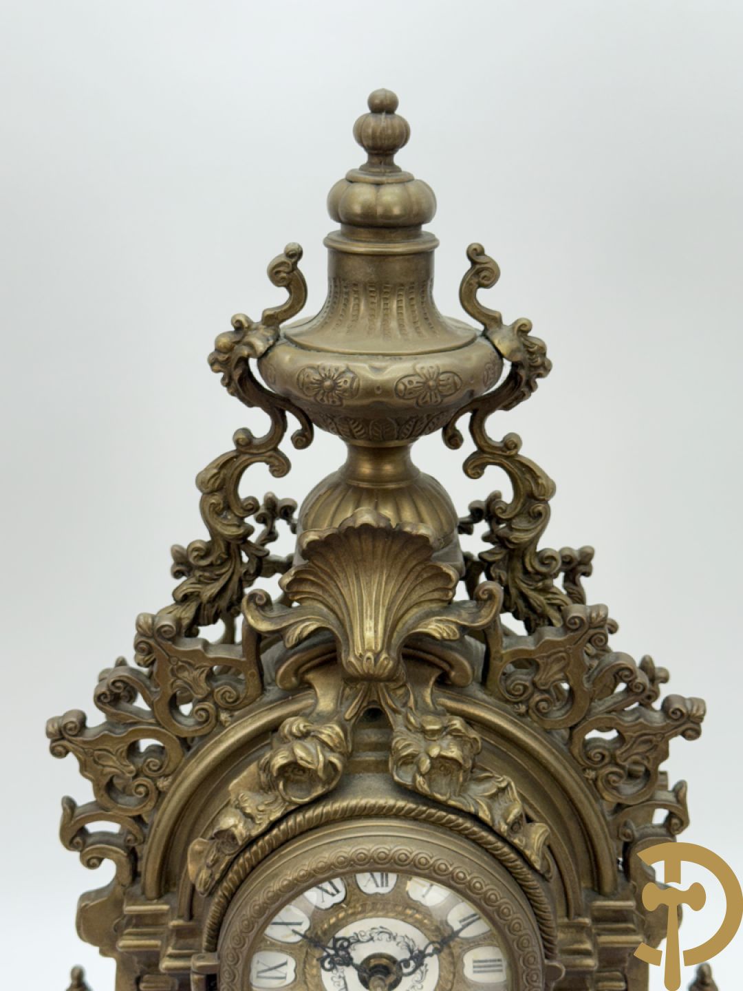 Driedelige koperen garnituur, klok geflankeerd door paar vijfarmige kandelaars