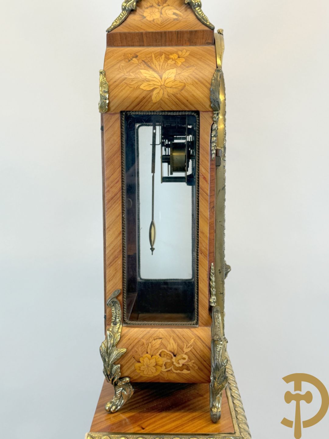 Notelaren pendule met bloemenmarquetterie en bronsbeslag, bovenaan bekroond met bronzen figuur - met bijhorende sokkel in notelaar met bronsbeslag