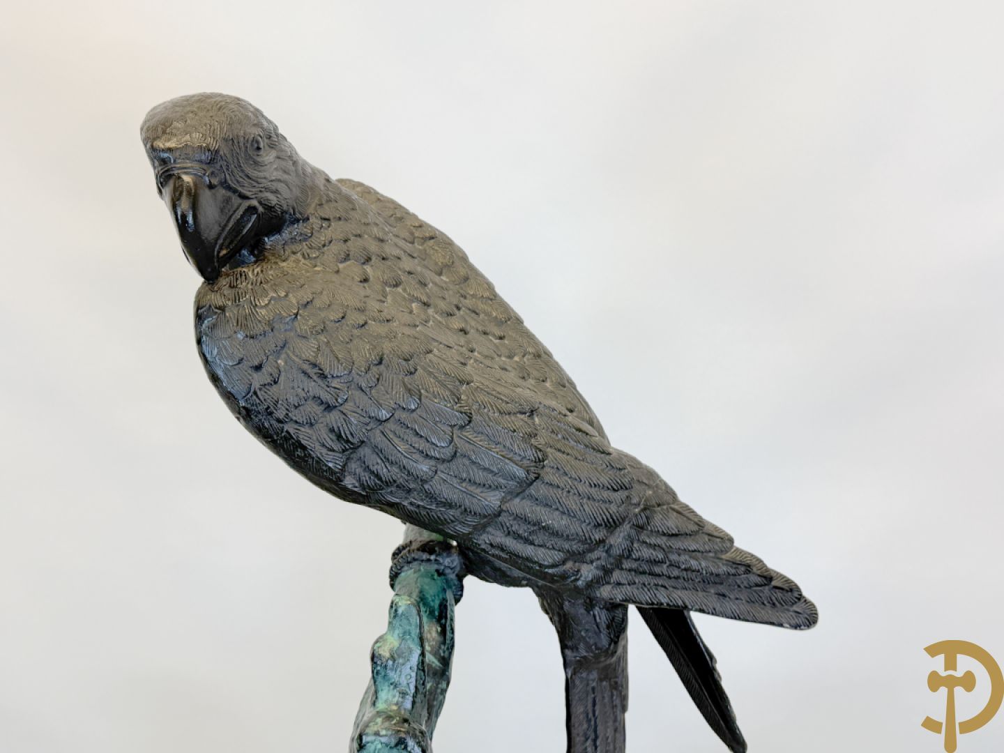 Metalen gepatineerde papegaai op boomstronk