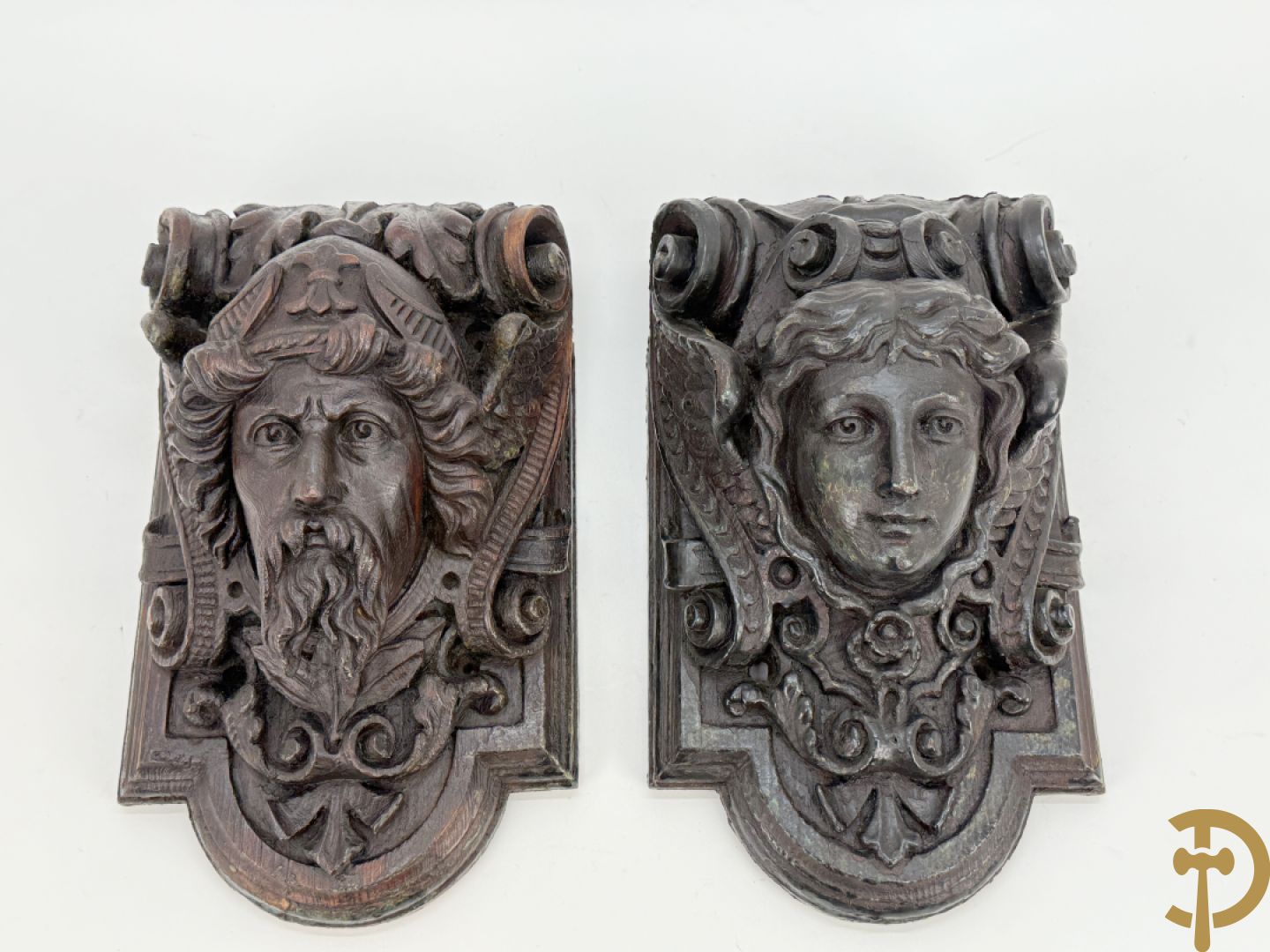 Paar muurhoeksteunen van hout met gesculpteerde hoofden man en vrouw