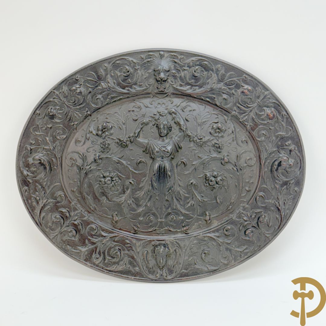 Metalen ovale schotel met dame omgeven door bloemen en accanthusranken, achteraan getekend American Radiator Cie