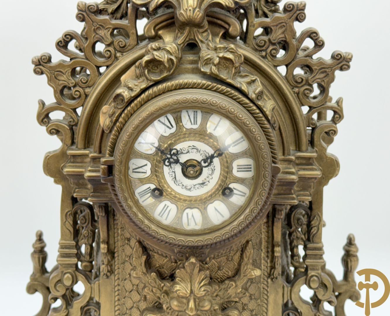 Driedelige koperen garnituur, klok geflankeerd door paar vijfarmige kandelaars