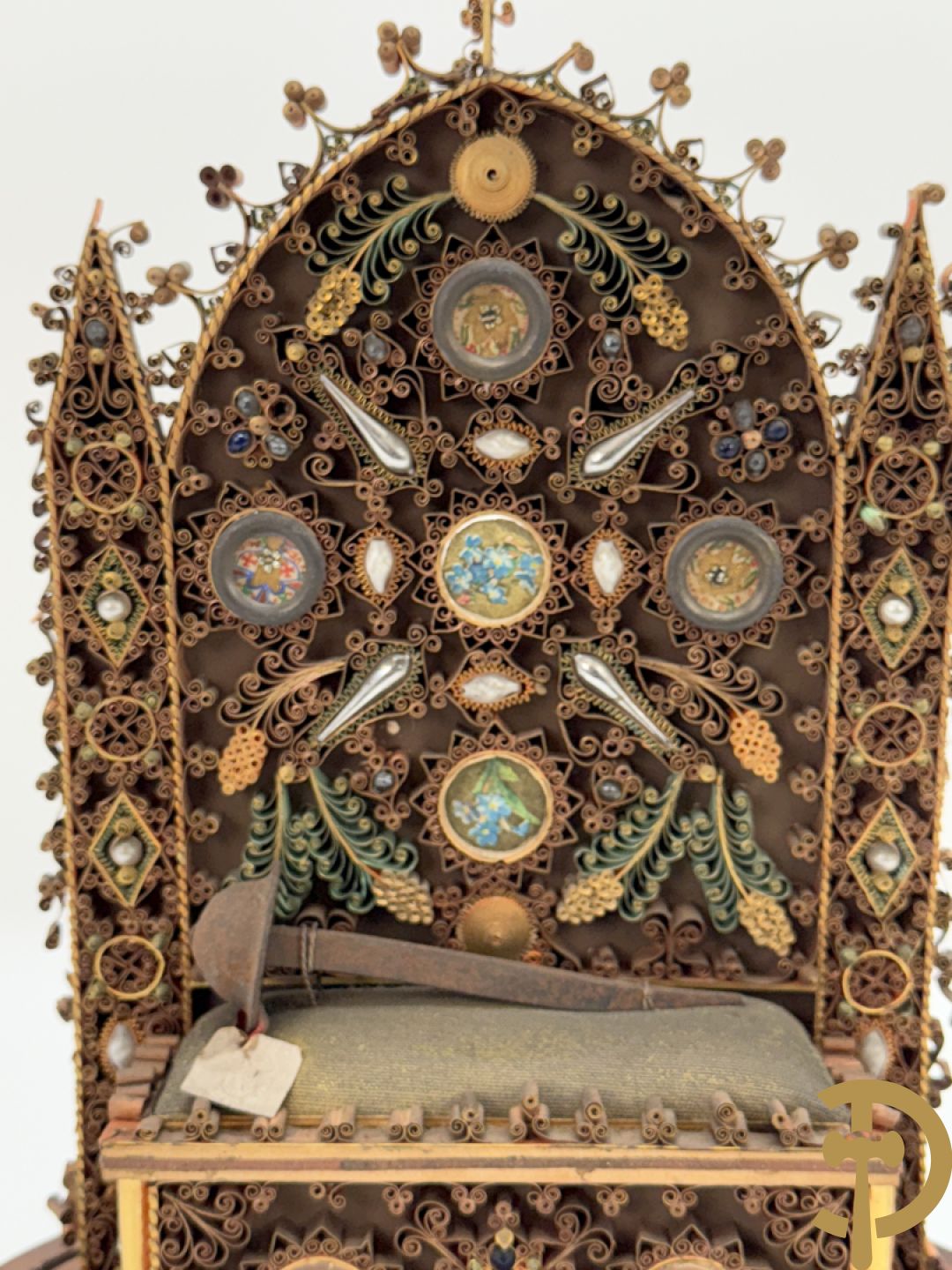 Relikwiehouder in de vorm van een altaar met Christusnagel en omgeven door papperollen - onder stolp