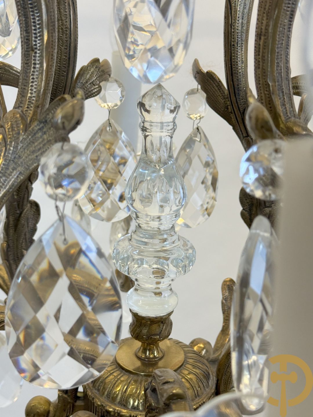 Achtarmige koperen luchter met kristallen bellen en binnenin met pinakel bezet