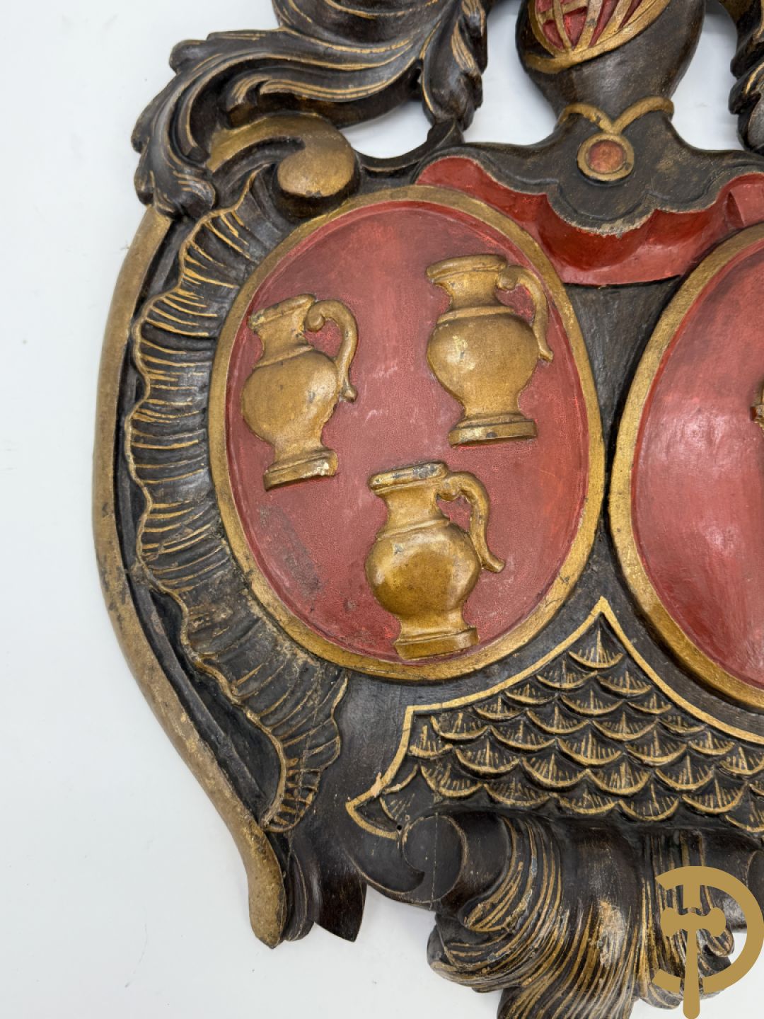 Houtgesculpteerd wapenschild met cartouche bovenaan en embleem met kannen en harp