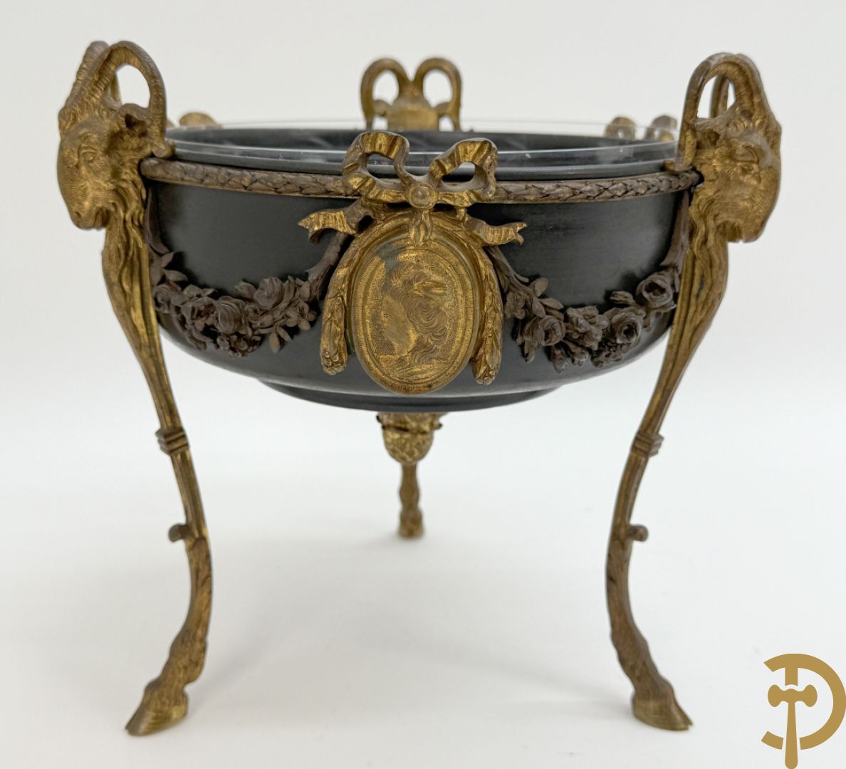 Bronzen coupe op 3 bokkepoten met ramskoppen  bezet en verbonden door guirlandes met medaillon