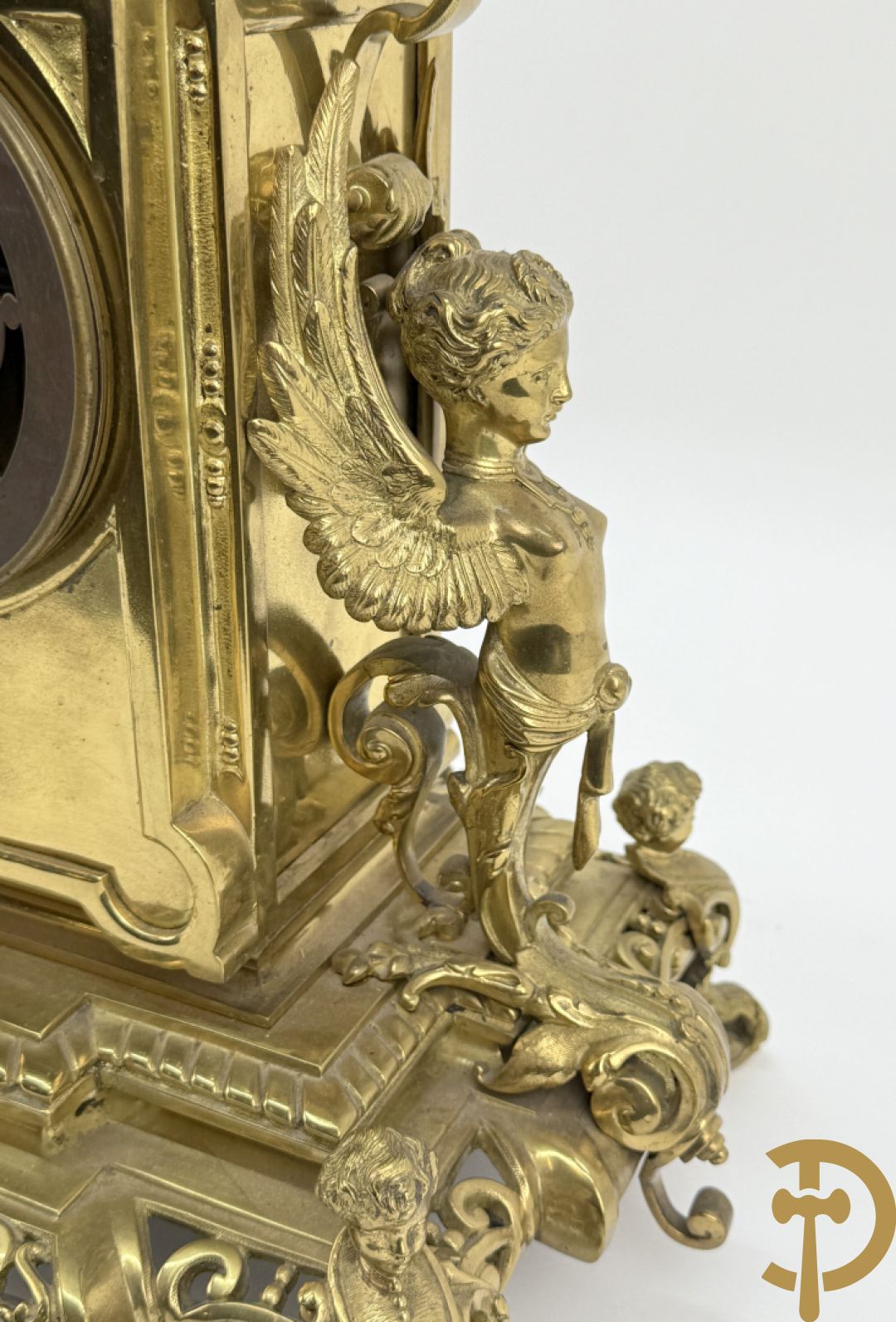 Driedelige bronzen vergulde garntiuur bestaande uit klok met medusahoofden en sfinxen, geflankeerd door paar zevenarmige kandelaars met accanthusranken en sfinxen