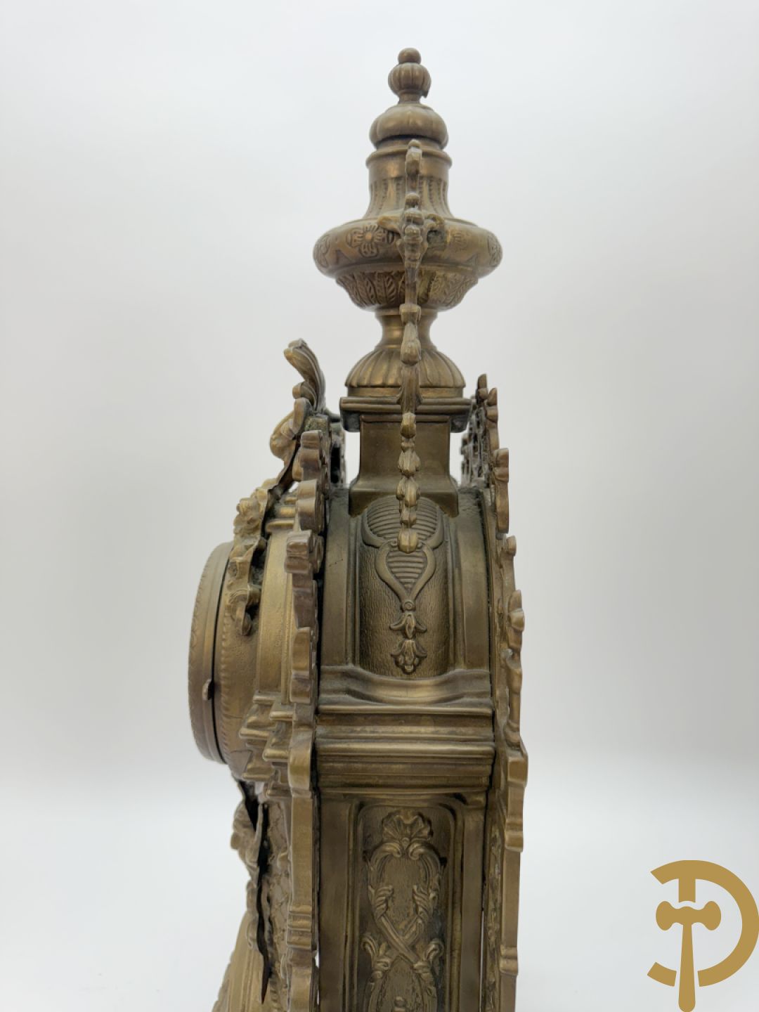 Driedelige koperen garnituur, klok geflankeerd door paar vijfarmige kandelaars