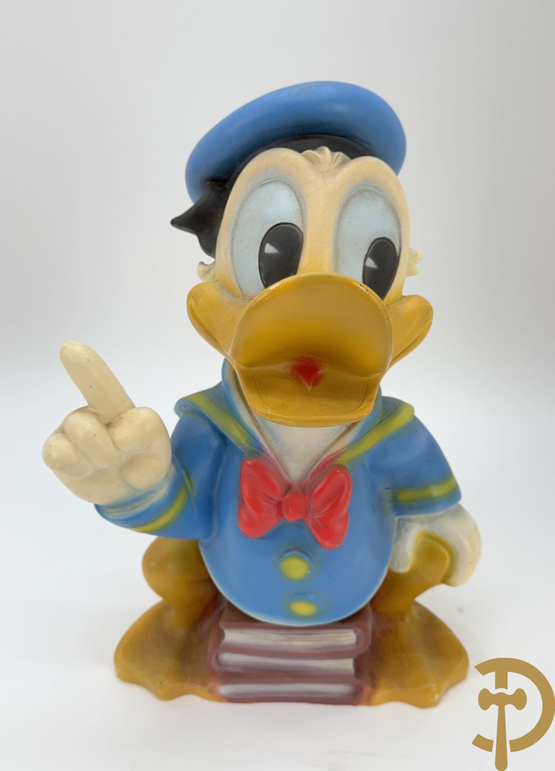Plastic Donald Duck zittend op 3 boeken, onderaan gemerkt Disney + houten gesculpteerd beschilderde eend