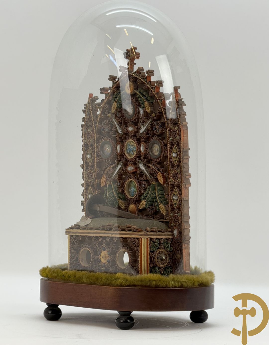 Relikwiehouder in de vorm van een altaar met Christusnagel en omgeven door papperollen - onder stolp