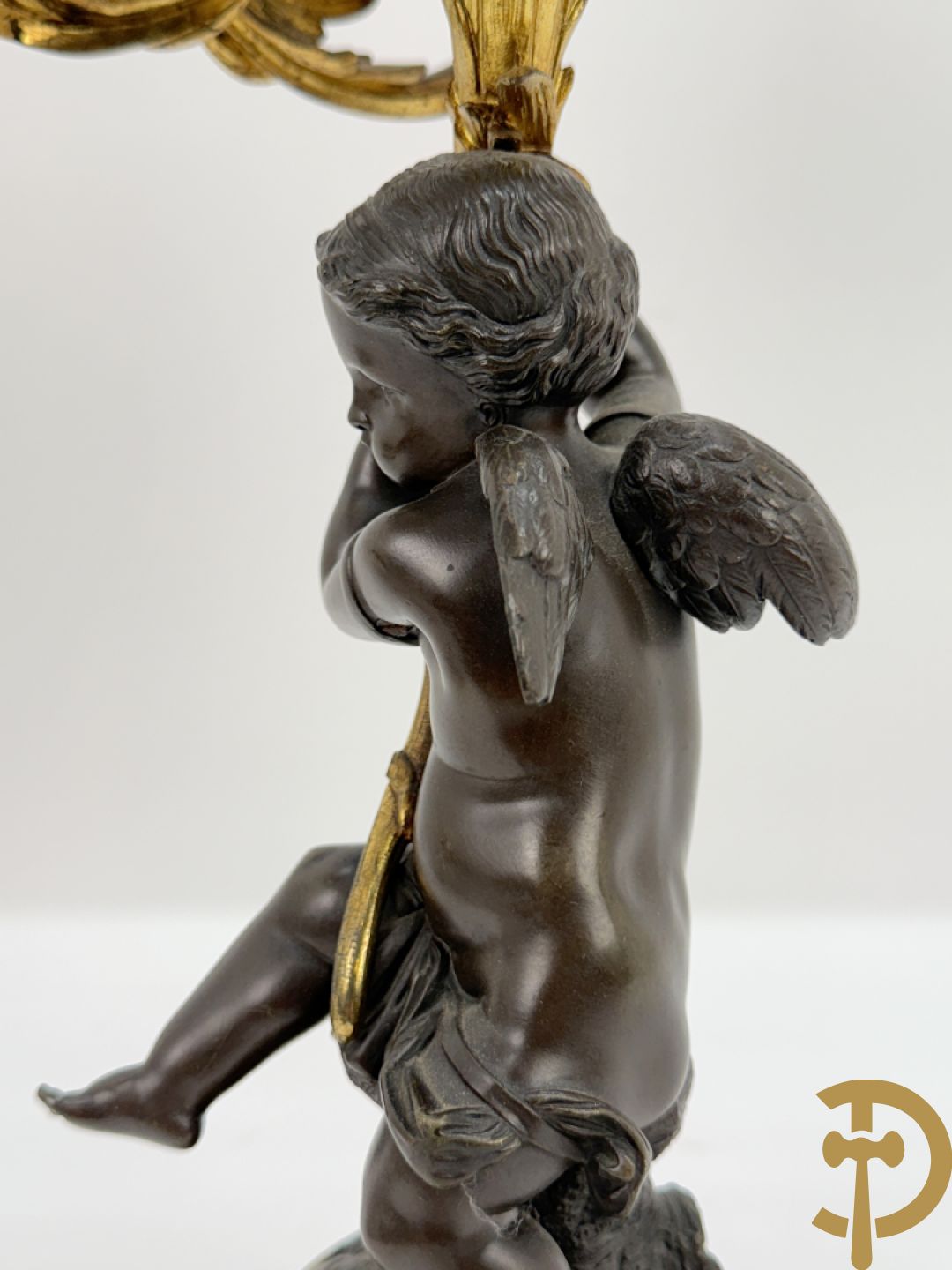 Bronzen cupido dragende een zevenarmige kandelaar