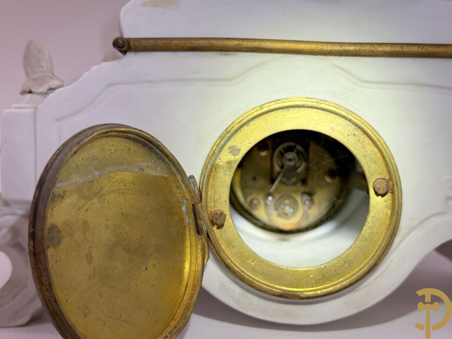 Driedelige porseleinen garnituur bestaande uit pendule bezet met lieftallig koppel, geflankeerd door paar kandelaars met cupido