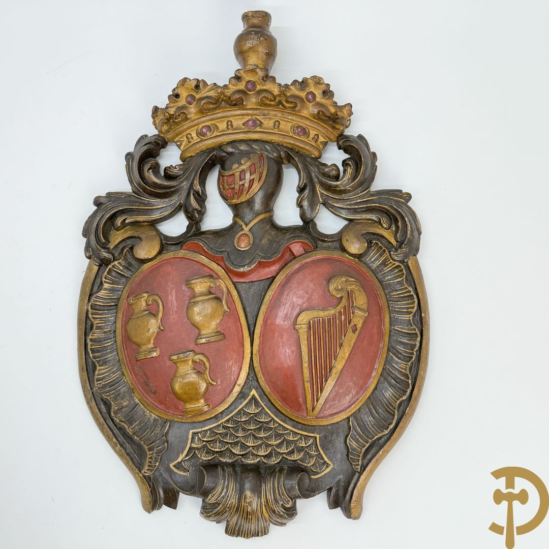 Houtgesculpteerd wapenschild met cartouche bovenaan en embleem met kannen en harp