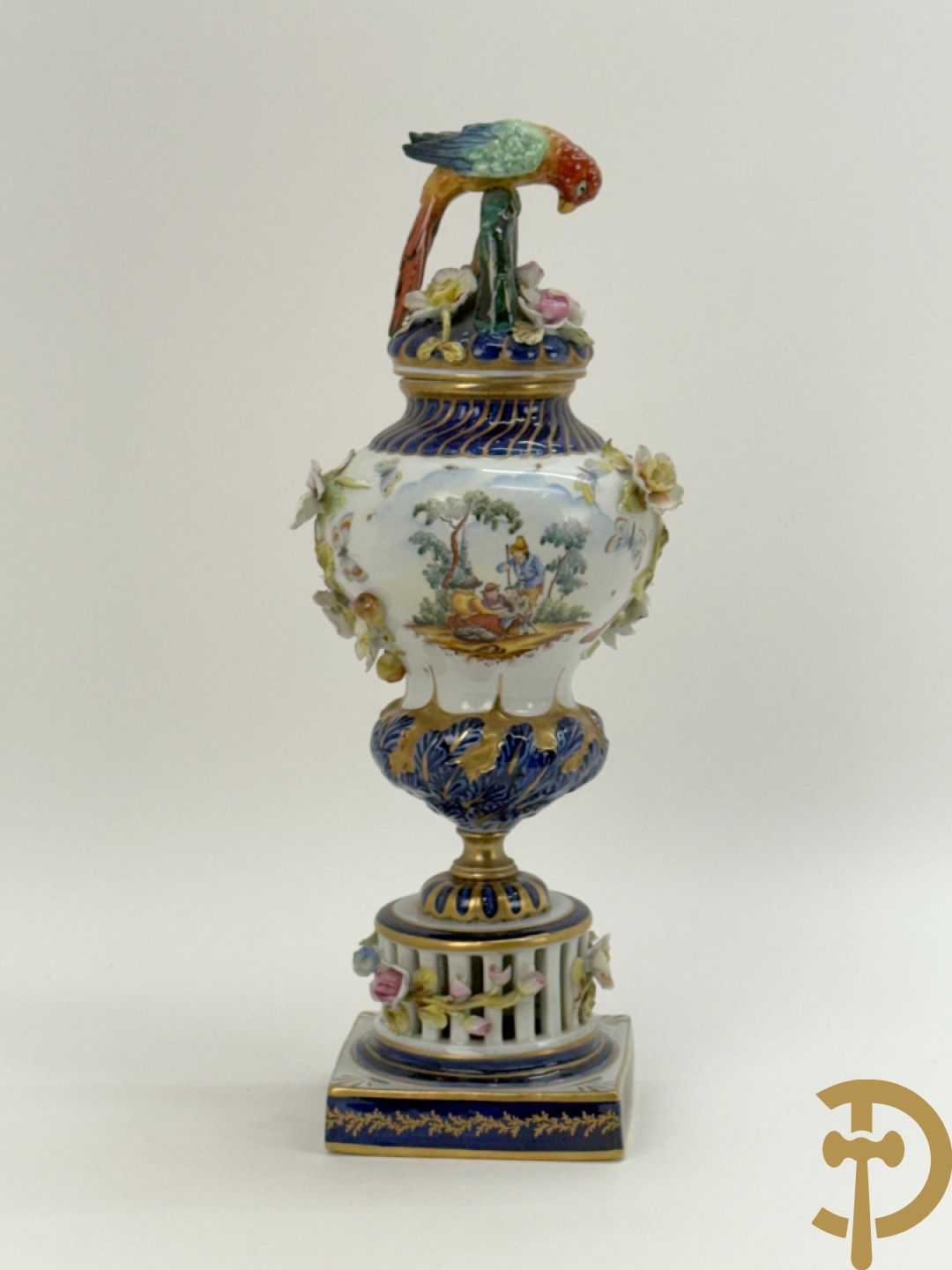 Porseleinen siervaas met handbeschilderd geanimeerd decor bezet met basrelief van bloemen en bovenaan bekroond met deksel met vogel