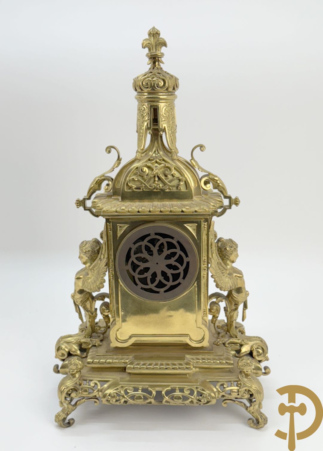 Driedelige bronzen vergulde garntiuur bestaande uit klok met medusahoofden en sfinxen, geflankeerd door paar zevenarmige kandelaars met accanthusranken en sfinxen