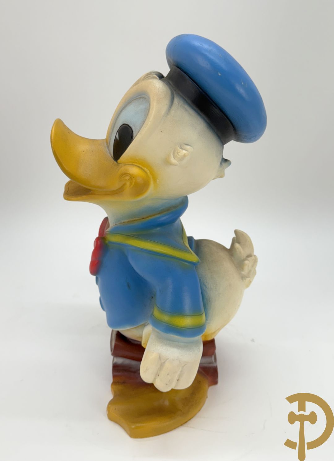 Plastic Donald Duck zittend op 3 boeken, onderaan gemerkt Disney + houten gesculpteerd beschilderde eend