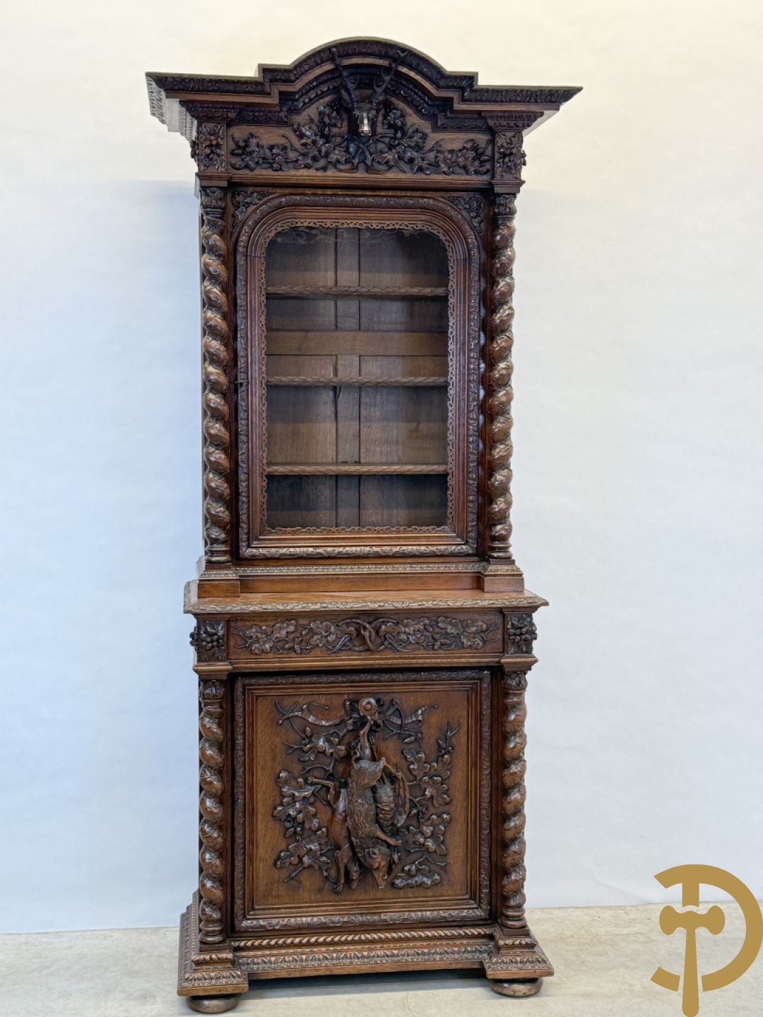 Massief eiken jacht deux-corps, bovenaan met vitrine, zijdelings met getorste zuilen, onderaan met sculptuur van everzwijn en eikebladranken