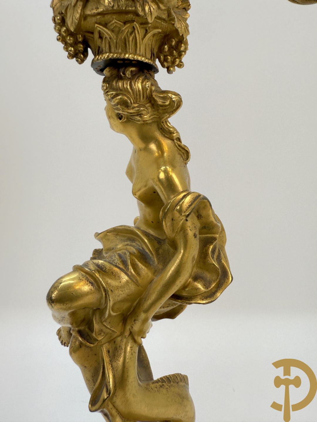 Paar bronzen kandelaars met sater en naakte dame, versierd met accanthusranken en dierenmotieven