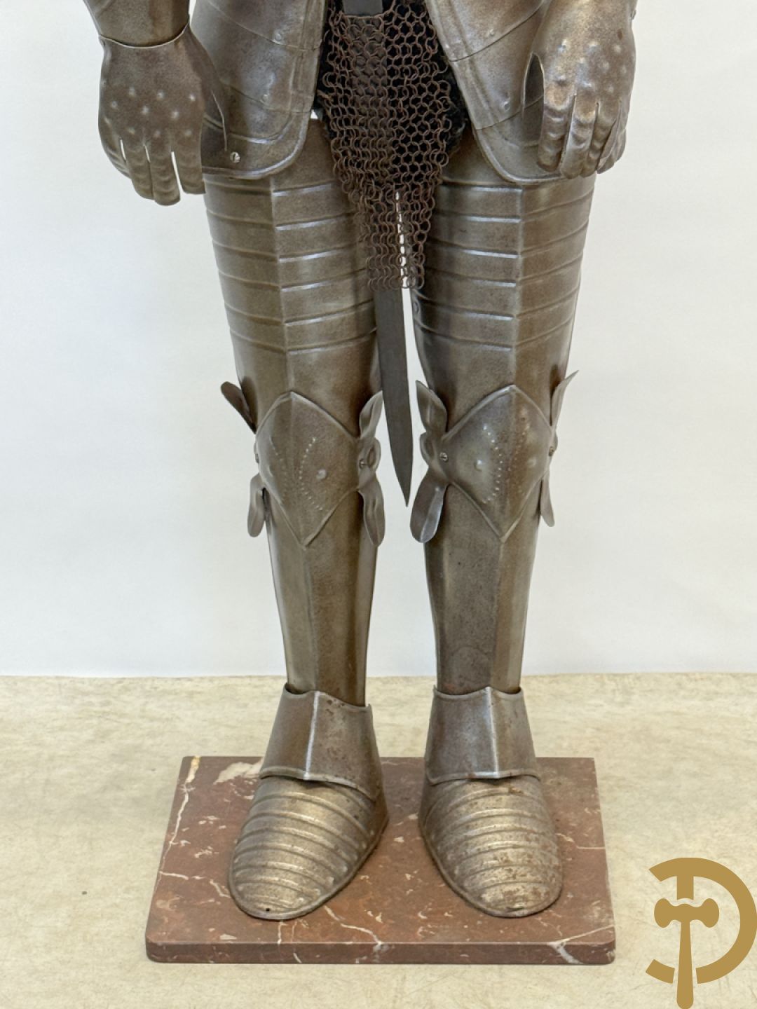 Decoratief plaatstalen ridderharnas met zwaard op marmeren voet