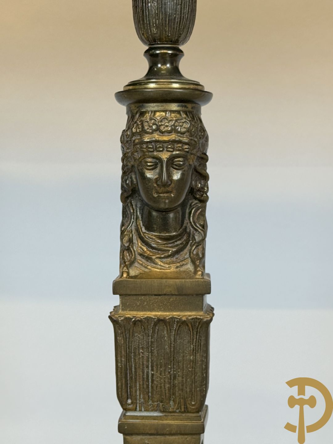 Console op bronzen poten met dameshoofden bezet, bovenaan met groen marmeren blad