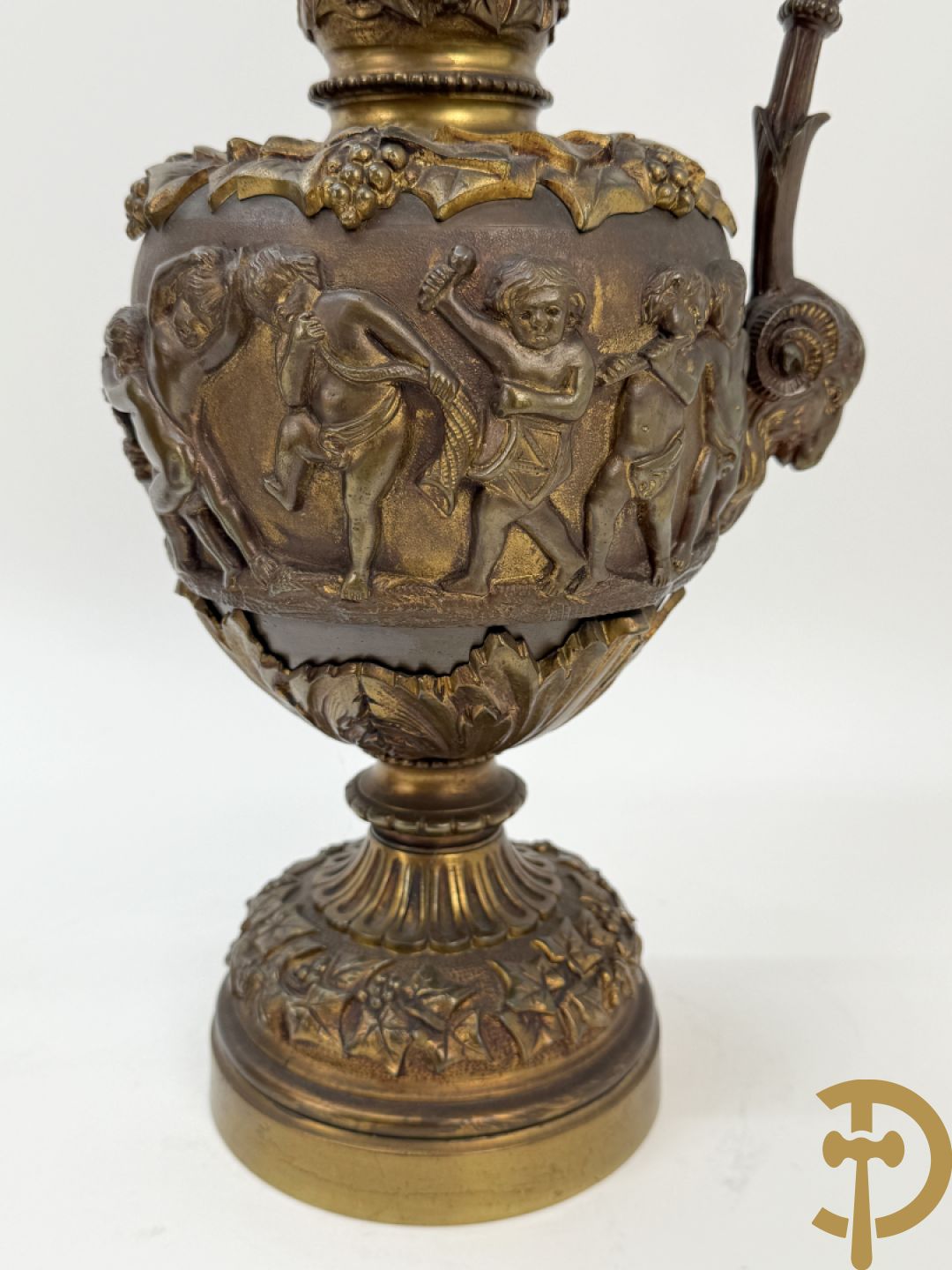Paar bronzen schenkkannen met basrelief van putti en accanthusranken