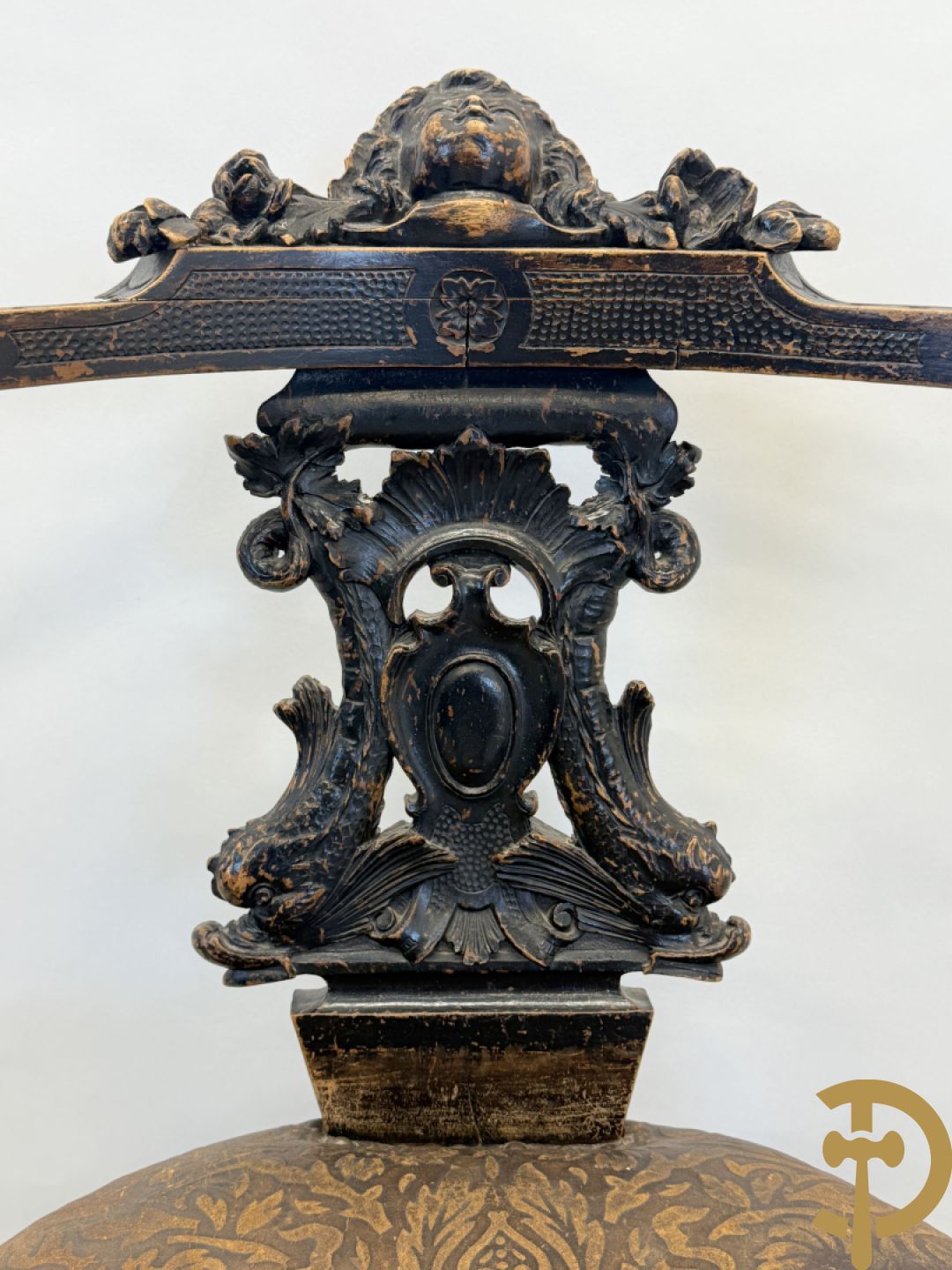 Gesculpteerde draaibare gondelvormige stoel steunend op 4 poten in de vorm van dolfijnen, bovenaan met kariathiden en engelenkoppen