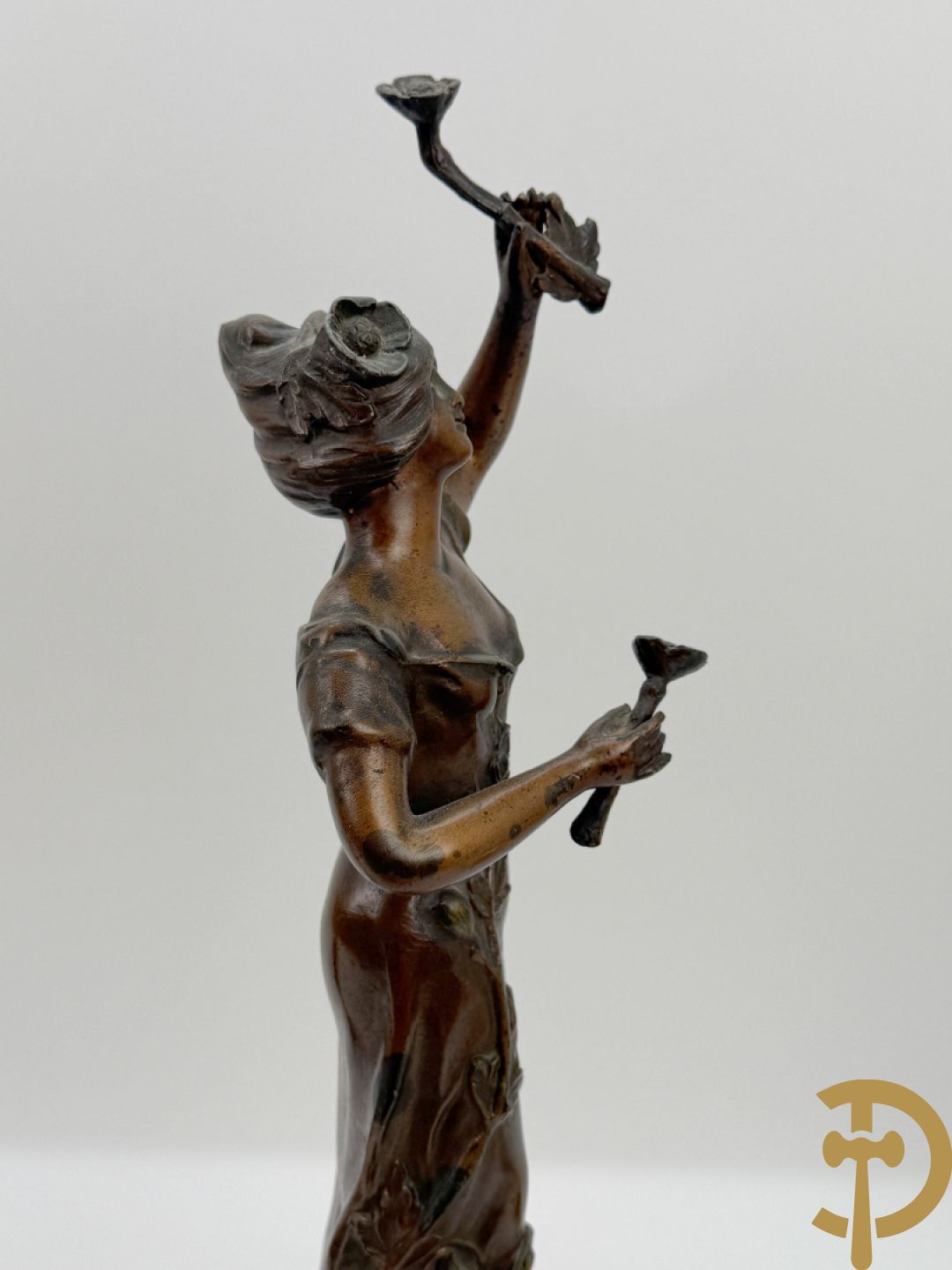 Driedelige zamak garnituur met dame Pavot met bloemen op uurwerk, Rucho getekend, geflankeerd door paar kandelaars