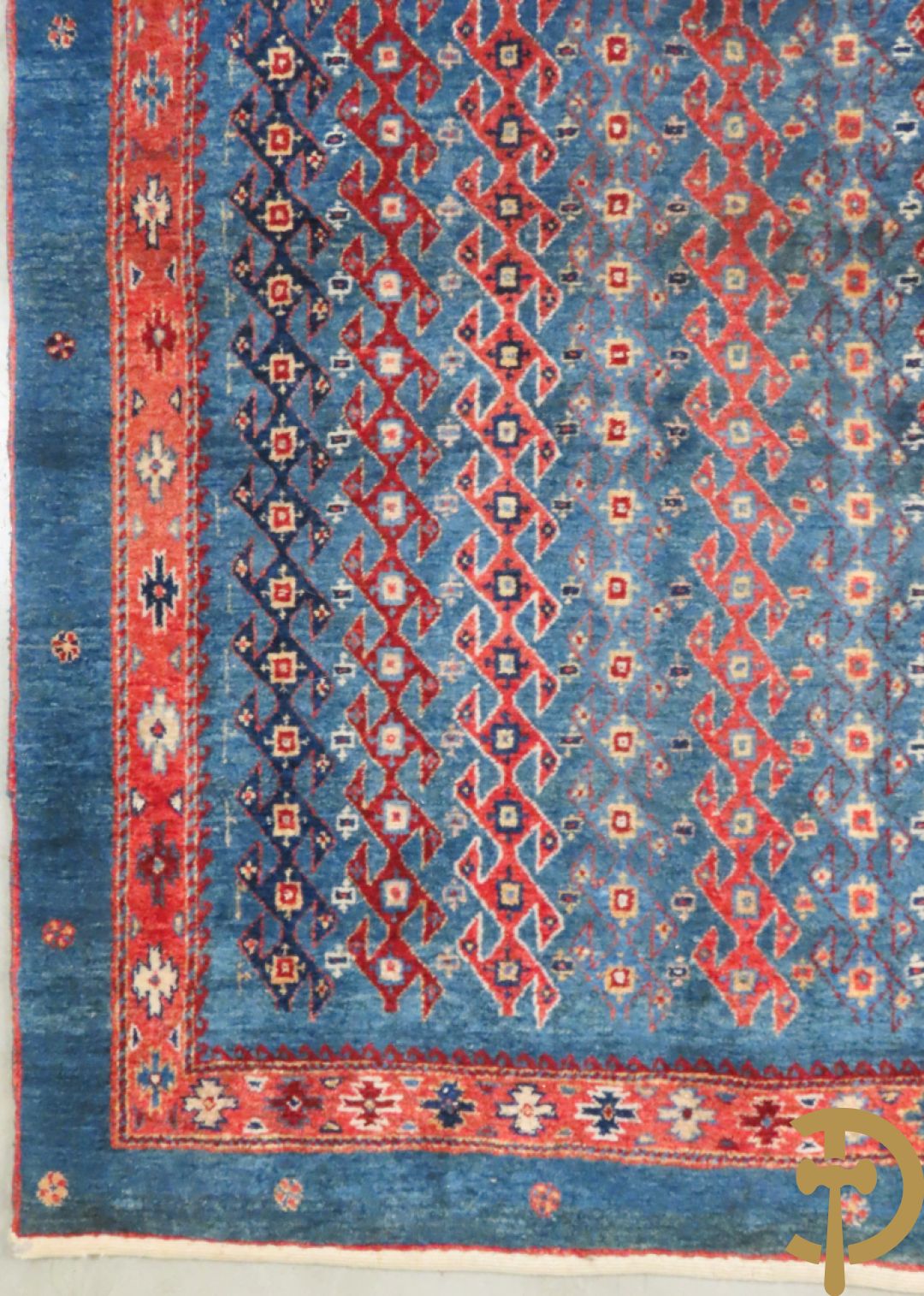 Oosters handgeknoopt tapijt met geometrische patronen op blauwe fond