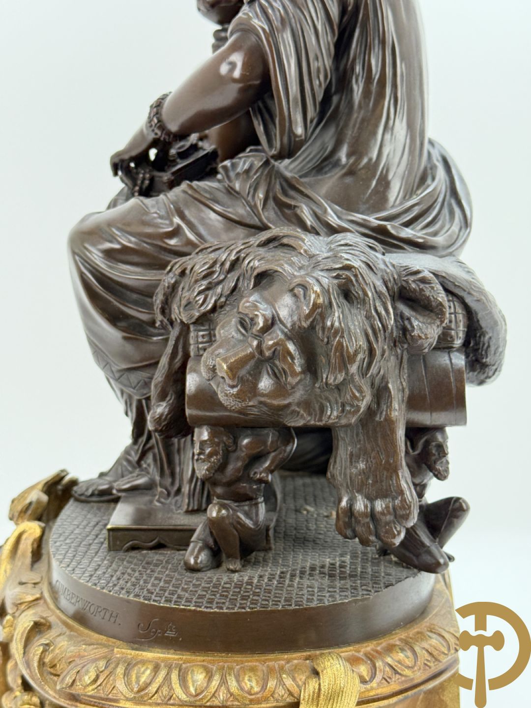 Driedelige bronzen garnituur bestaande uit middenstuk met bronzen vuurvergulde klok, Daubrée gemerkt à Nancy, bovenaan bekroond met Cleopatra met drinkbeker - getekend van Cumberworth sculpteur - geflankeerd door paar cupido